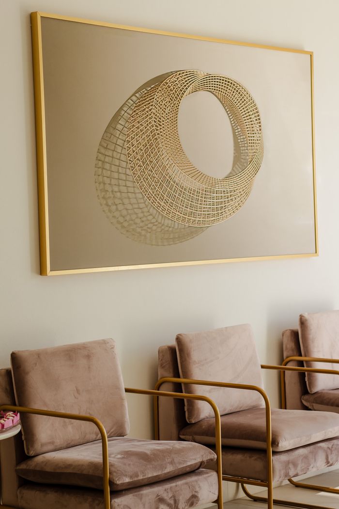 Stylish minimalist seating area featuring cozy chairs and geometric wall art in a serene setting.