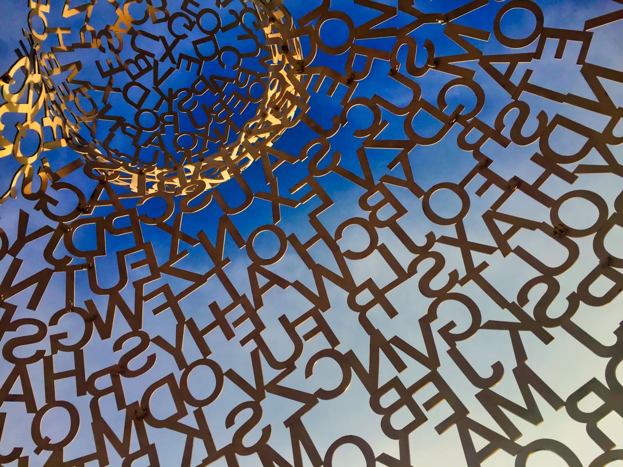Intricate Le Nomade sculpture against a vivid blue sky in Antibes, France.